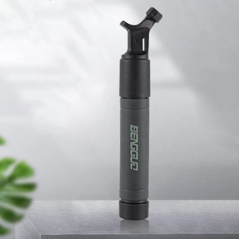 A compact black inflation ball pump with a nozzle at the top