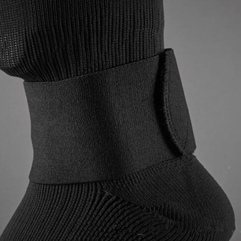 A close up of black shin guard fixed bandage tape